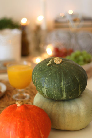 Pumpkins, various food and drinks, fall decorations, books and candles on the table. Fall hygge at home. Selective focus.の写真素材
