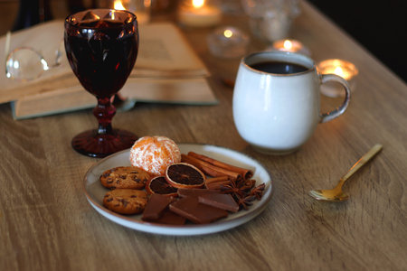 Books, lit candles, red wine, snacks and various deocration on the table. Dark academia or Halloween concept. Selective focus.の写真素材