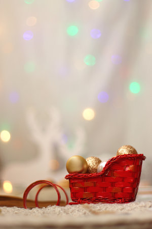 Various Christmas decorations, lit candles, cup of tea or coffee, cookies, books, presents and soft blanket on the table. Holiday hygge at home. Selective focus.の写真素材