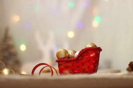 Various Christmas decorations, lit candles, cup of tea or coffee, cookies, books, presents and soft blanket on the table. Holiday hygge at home. Selective focus.の写真素材
