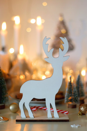 Various Christmas decorations, cookies, chocolate, nuts and tangerines, wine glasses and lit candles on the table. Holiday hygge at home. Selective focus.の写真素材