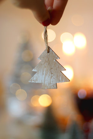 Various Christmas decorations, cookies, chocolate, nuts and tangerines, wine glasses and lit candles on the table. Holiday hygge at home. Selective focus.の写真素材