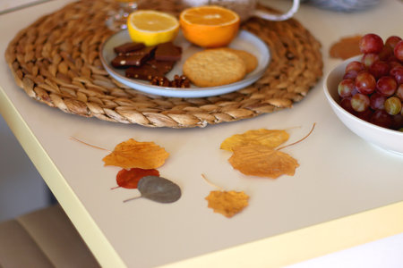 Pumpkins, various food and drinks, fall decorations, books and candles on the table. Fall hygge at home. Selective focus.の写真素材
