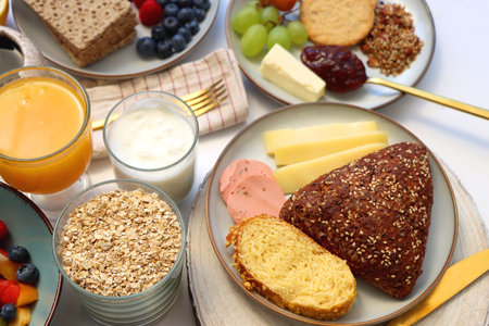 Assortment of various breakfast foods and drinks on the white table. Selective focus.の写真素材