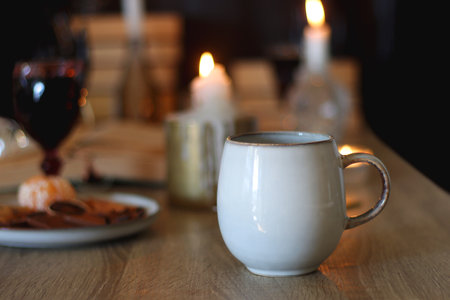 Books, lit candles, red wine, snacks and various deocration on the table. Dark academia or Halloween concept. Selective focus.の写真素材
