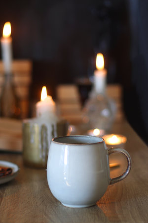 Books, lit candles, red wine, snacks and various deocration on the table. Dark academia or Halloween concept. Selective focus.の写真素材