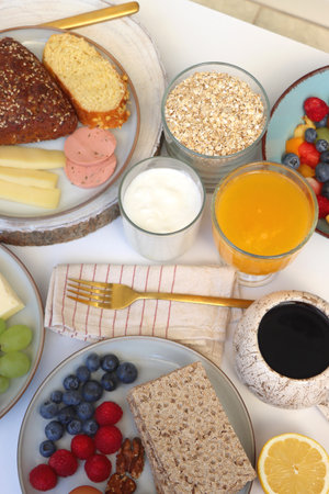 Assortment of various breakfast foods and drinks on the white table. Selective focus.の写真素材