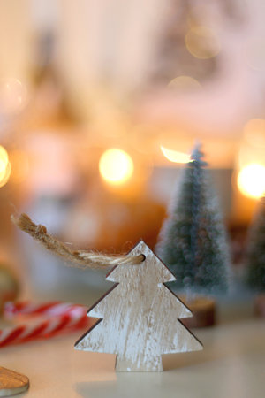 Various Christmas decorations, cookies, chocolate, nuts and tangerines, wine glasses and lit candles on the table. Holiday hygge at home. Selective focus.の写真素材