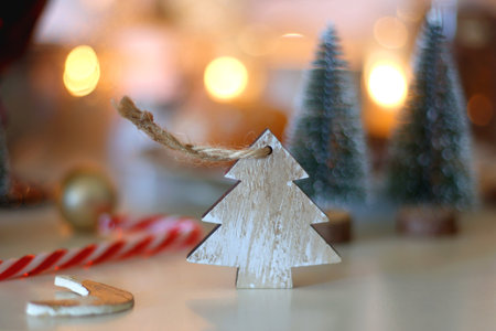 Various Christmas decorations, cookies, chocolate, nuts and tangerines, wine glasses and lit candles on the table. Holiday hygge at home. Selective focus.の写真素材