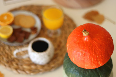 Pumpkins, various food and drinks, fall decorations, books and candles on the table. Fall hygge at home. Selective focus.の写真素材