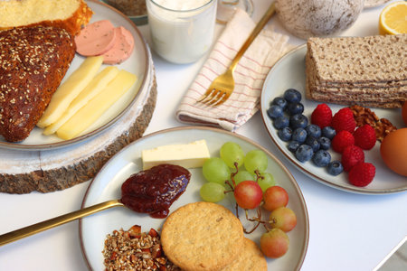 Assortment of various breakfast foods and drinks on the white table. Selective focus.の写真素材