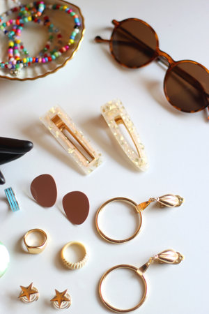 Hand figurine, sunglasses, gold jewelry, colorful bead jewelry, statement rings and various hair...