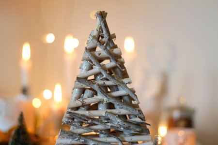 Various Christmas decorations, cookies, chocolate, nuts and tangerines, wine glasses and lit candles on the table. Holiday hygge at home. Selective focus.の写真素材