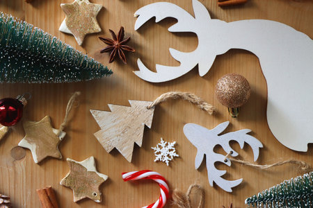 Various Christmas decorations in neutral colors on wooden background. Flat lay.