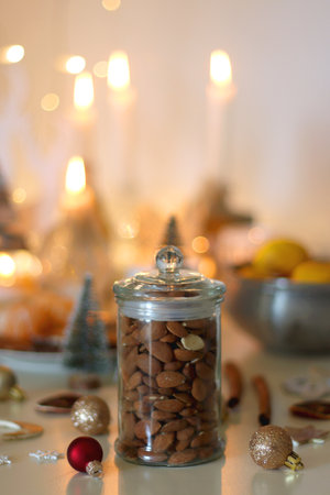 Various Christmas decorations, chocolate, nuts and tangerines, lit candles on the table. Holiday hygge at home. Selective focus.の写真素材