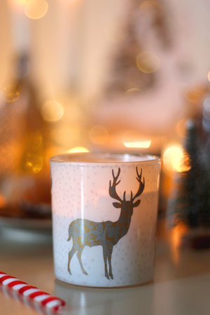 Various Christmas decorations, cookies, chocolate, nuts and tangerines, wine glasses and lit candles on the table. Holiday hygge at home. Selective focus.の写真素材