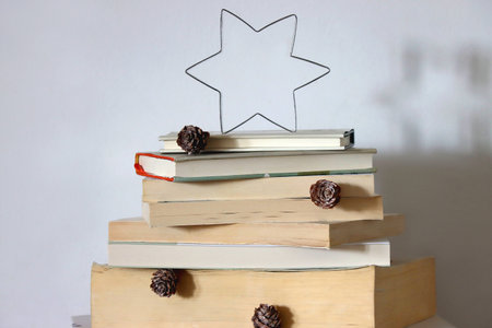 Christmas tree made with stack of books. Cute Christmas tree for booklovers. Selective focus.の写真素材