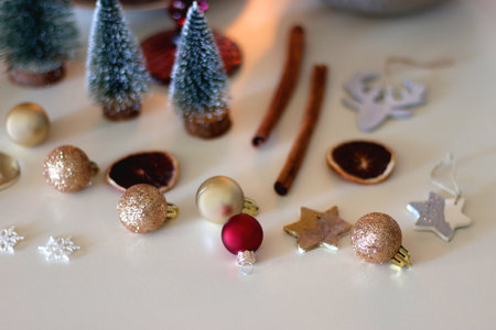 Various Christmas decorations, cookies, chocolate, nuts and tangerines, wine glasses and lit candles on the table. Holiday hygge at home. Selective focus.の写真素材