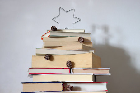 Christmas tree made with stack of books. Cute Christmas tree for booklovers. Selective focus.の写真素材
