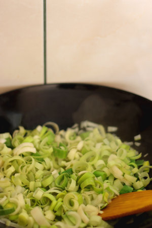 Sauteing chopped leek slices in a wok. Selective focus.の写真素材