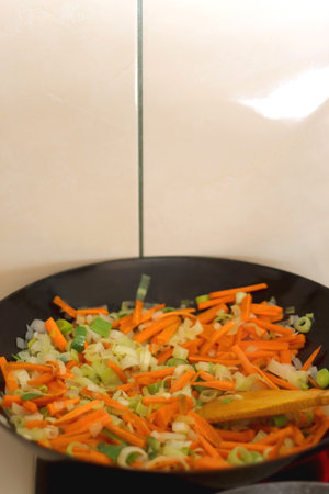 Sauteing chopped leek and carrot slices in a wok. Selective focus.の写真素材
