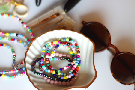 Hand figurine, sunglasses, gold jewelry, colorful bead jewelry, statement rings and various hair...