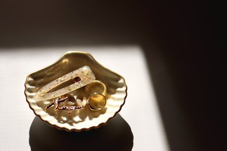 White shell shaped trinket with gold and beige accessories. Selective focus, white background.の写真素材