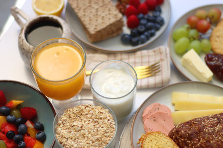 Assortment of various breakfast foods and drinks on the white table. Selective focus.の写真素材