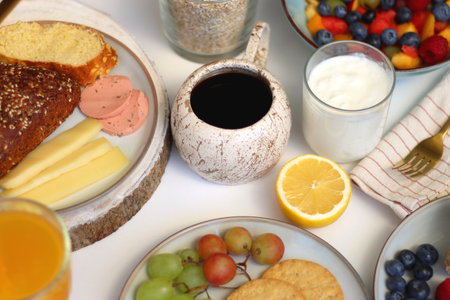 Assortment of various breakfast foods and drinks on the white table. Selective focus.の写真素材