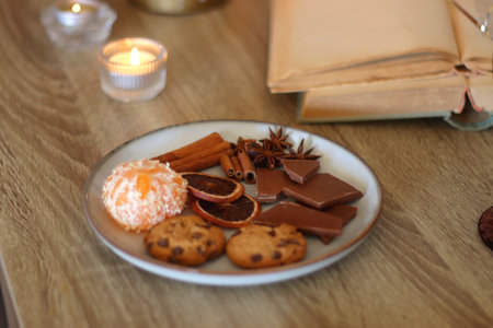 Books, lit candles, snacks and various decoration on the table. Dark academia or Halloween concept. Selective focus.の写真素材