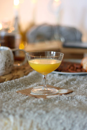 Books, tea, orange juice, fruit, snacks, yarn, blanket and lit candles on the table. Autumn or winter hygge at home. Selective focus.の写真素材