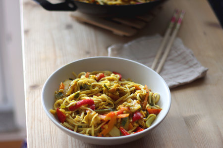 Bowl of stir fry vegetables and noodles, served on the table. Selective focus.の写真素材