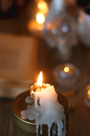 Books, lit candles, red wine, snacks and various deocration on the table. Dark academia or Halloween concept. Selective focus.の写真素材