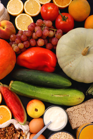 Various healthy fruits, vegetables and cereals on dark background. Top view.