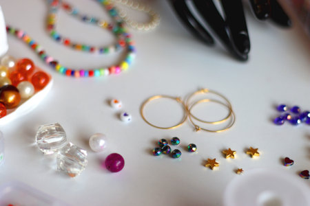 Friendship bracelet spelled with letter beads. Colorful handmade bracelets and various jewelry making supplies. Selective focus, white background.の写真素材