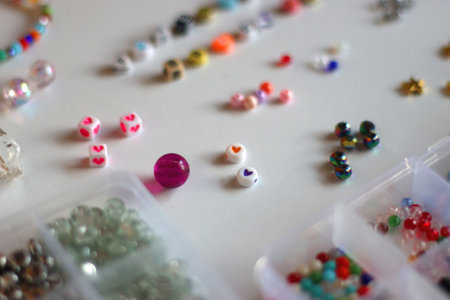 Friendship bracelet spelled with letter beads. Colorful handmade bracelets and various jewelry making supplies. Selective focus, white background.の写真素材