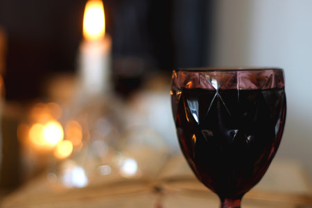 Books, lit candles, red wine, snacks and various deocration on the table. Dark academia or Halloween concept. Selective focus.の写真素材