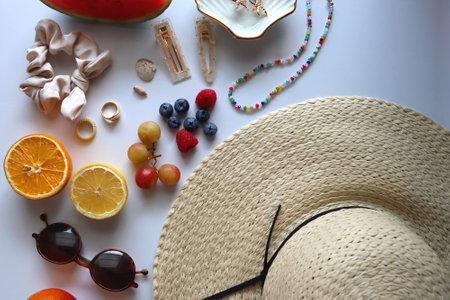 Straw hat, sunglasses, seasonal fruit, seashells and colorful accessories on white backgrounds. Cute summer essentials. Flat lay.の写真素材