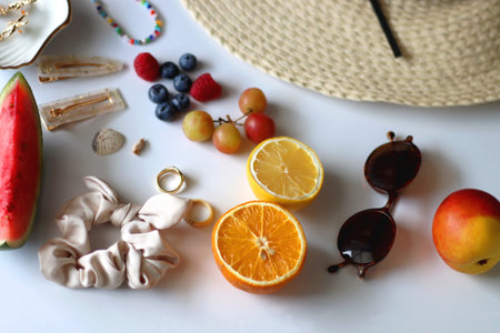 Straw hat, sunglasses, seasonal fruit, seashells and colorful accessories on white backgrounds. Cute summer essentials. Selective focus.の写真素材