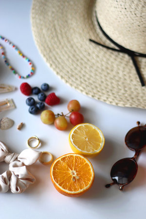 Straw hat, sunglasses, seasonal fruit, seashells and colorful accessories on white backgrounds. Cute summer essentials. Selective focus.の写真素材