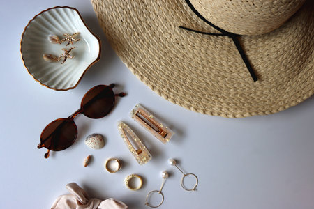 Straw hat, colorful beaded necklace and sunglasses on the wooden table. Summer essentials concept. Selective focus.の写真素材