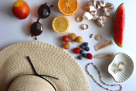 Straw hat, sunglasses, seasonal fruit, seashells and colorful accessories on white backgrounds. Cute summer essentials. Flat lay.の写真素材