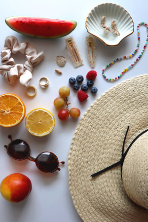 Straw hat, sunglasses, seasonal fruit, seashells and colorful accessories on white backgrounds. Cute summer essentials. Flat lay.の写真素材