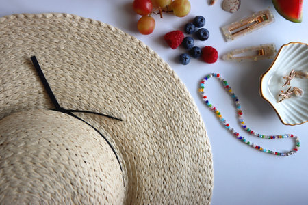 Straw hat, sunglasses, seasonal fruit, seashells and colorful accessories on white backgrounds. Cute summer essentials. Flat lay.の写真素材