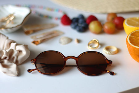 Straw hat, sunglasses, seasonal fruit, seashells and colorful accessories on white backgrounds. Cute summer essentials. Selective focus.の写真素材
