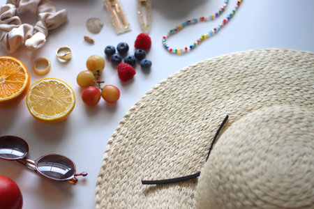 Straw hat, sunglasses, seasonal fruit, seashells and colorful accessories on white backgrounds. Cute summer essentials. Selective focus.の写真素材