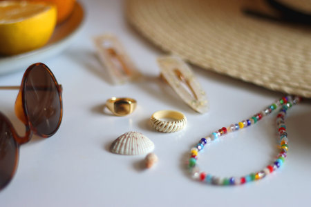 Straw hat, sunglasses, fresh fruit, chocolate and accessories. Summer essentials on the table. Selective focus.の写真素材