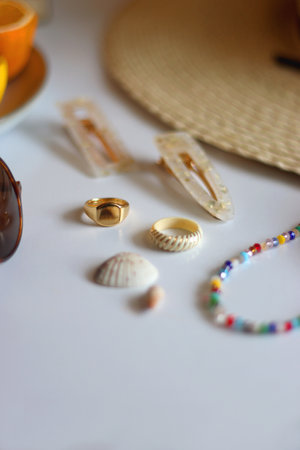 Glass, straw hat, sunglasses, fresh fruit, chocolate and accessories. Summer essentials on the table. Selective focus.の写真素材