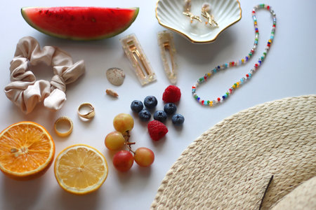 Straw hat, sunglasses, seasonal fruit, seashells and colorful accessories on white backgrounds. Cute summer essentials. Selective focus.の写真素材