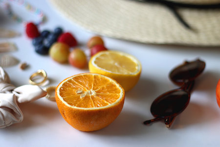 Straw hat, sunglasses, seasonal fruit, seashells and colorful accessories on white backgrounds. Cute summer essentials. Selective focus.の写真素材